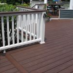 A brown Trex deck with a white guardrail.