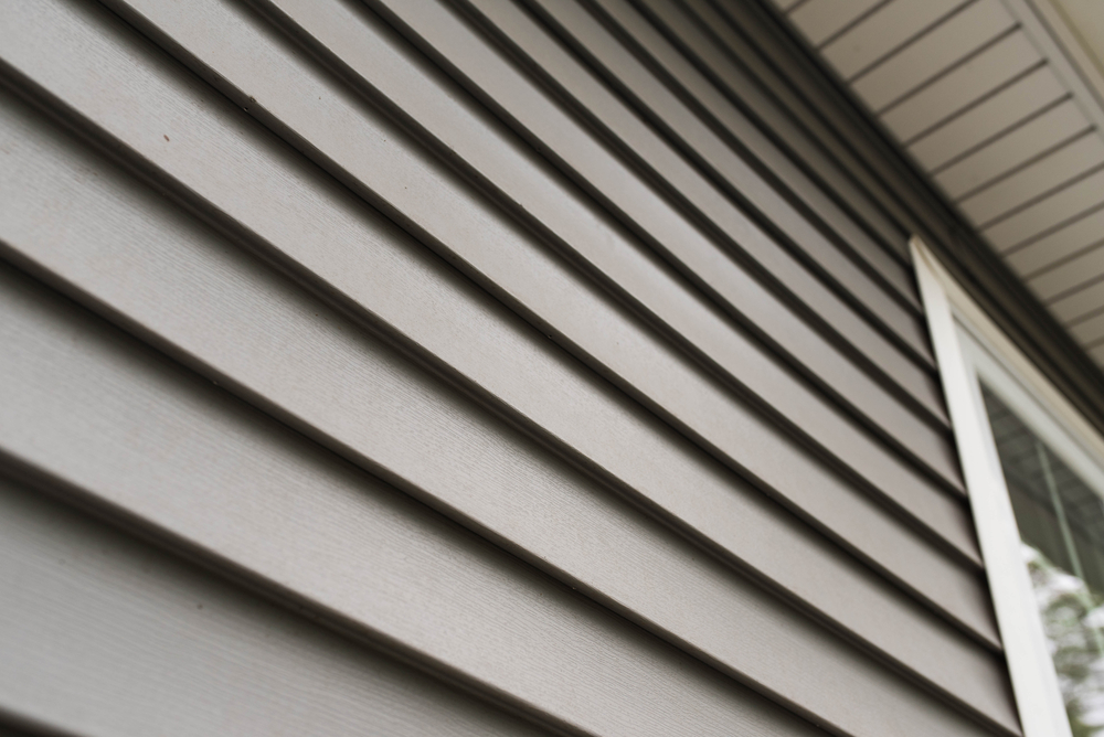 A close up look at grey vinyl siding on the side of a home.